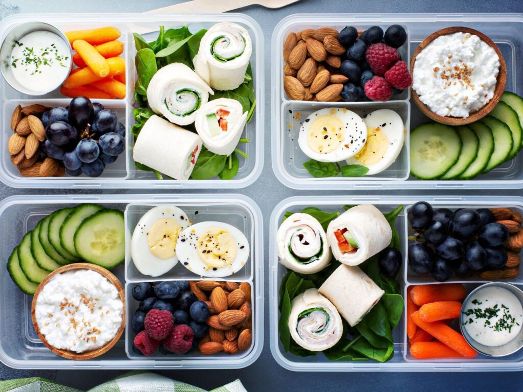 Your paragraph text A beautifully organized bento box with different compartments, one holding a pasta salad, another with edamame and a hard-boiled egg, and a small section with a handful of berries. All elements look fresh and appealing.