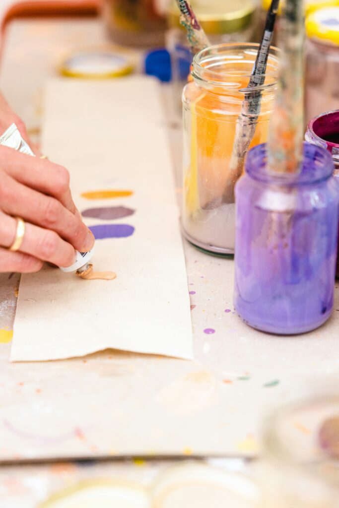 filipp-romanovski-ek_N7jxMt8c-unsplash a woman painting pn a canvas