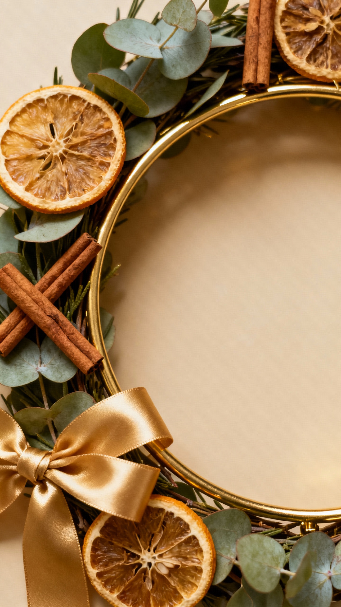 Closeup brass ring wreath with eucalyptus, dried oranges, cinnamon, satin ribbon
