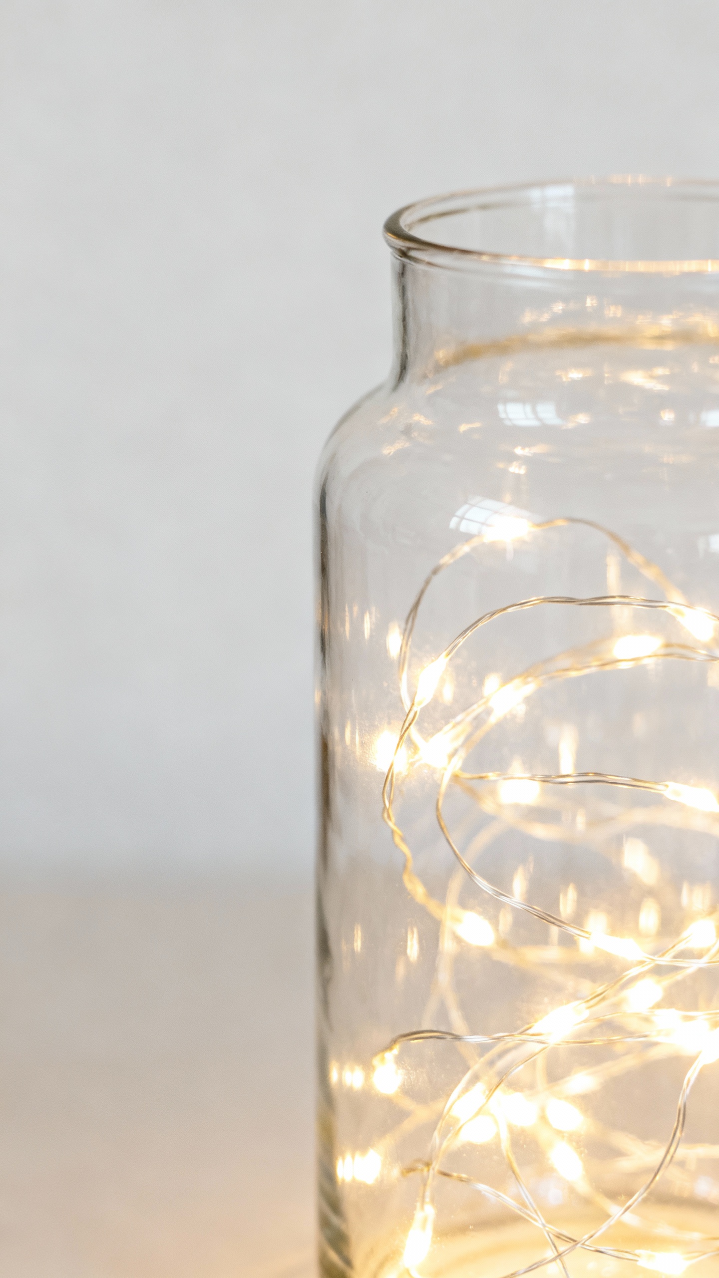 Closeup warm-white string lights in glass vessel, twinkle glow