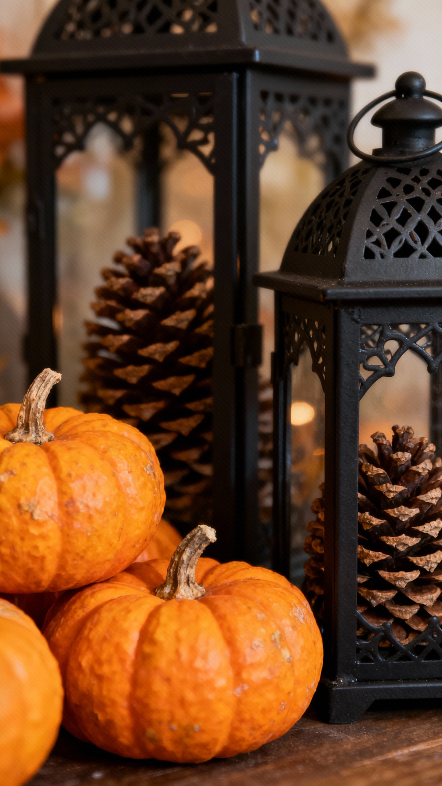 Clustered pumpkins beside black metal lanterns with faux pinecones